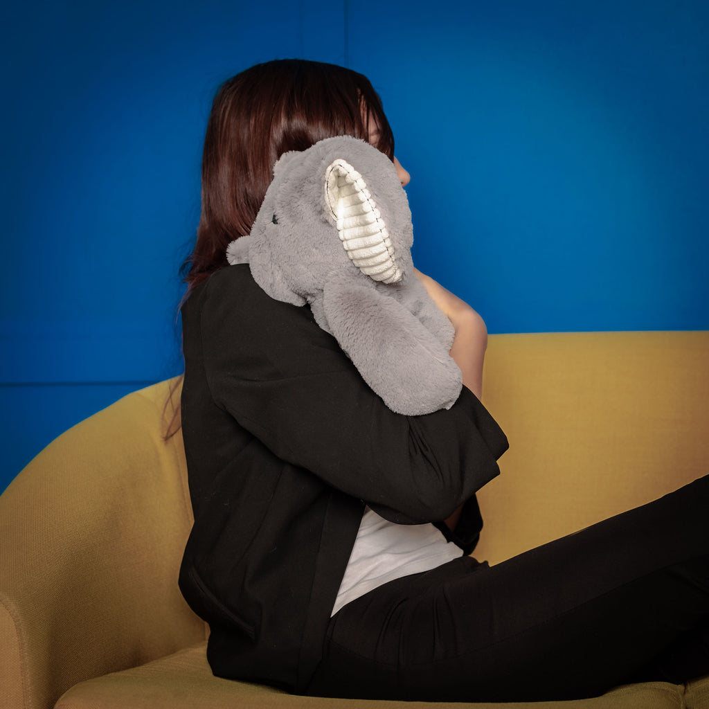 Girl cuddling Empowerment Elephant on a couch